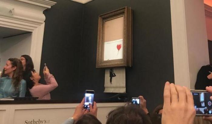 Scherza o siamo desti? Banksy tritura una sua opera venduta all'asta